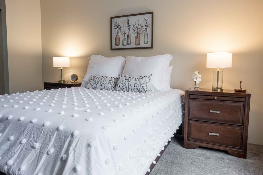 A comfortable, well-lit bedroom in a private apartment at Augustine Landing, a community offering senior living near Orange Park.