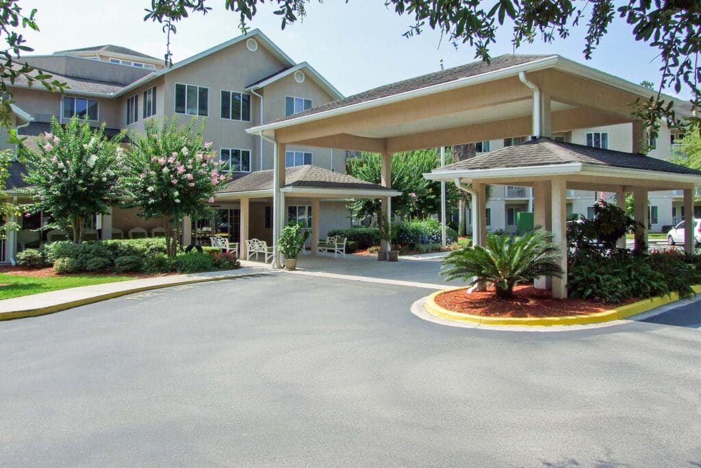 Augustine Landing main building entrance during the day, with blooming trees on each side of the building.
