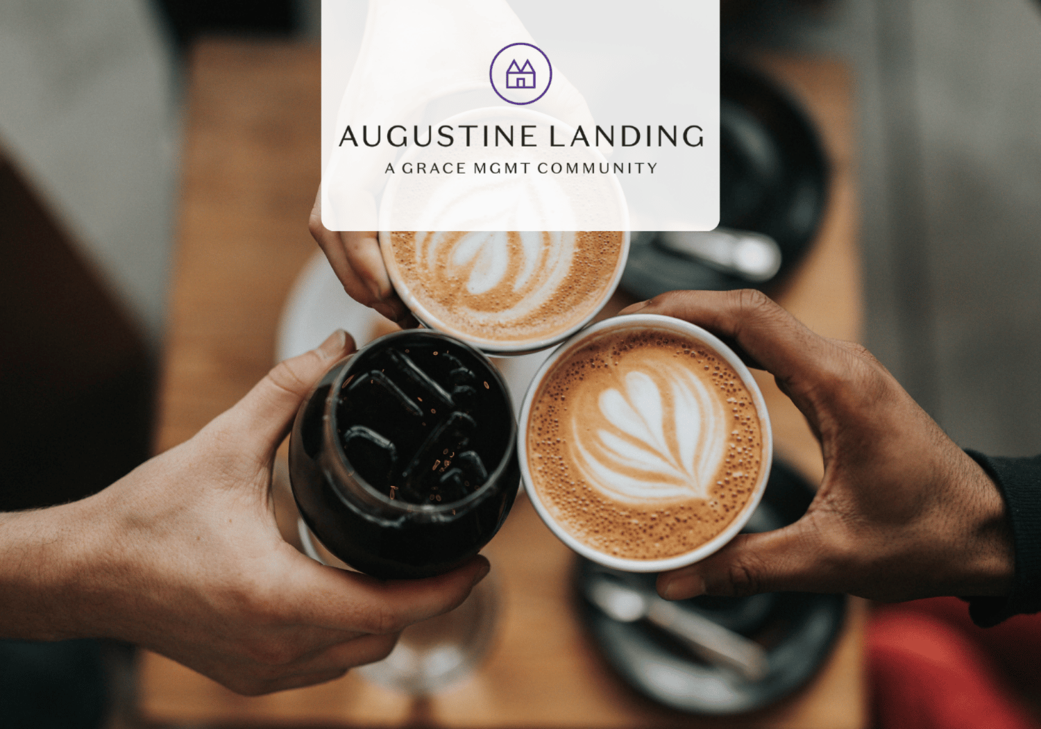 Three hands toast with three cups of coffee, latte art visible, overlaid with Augustine Landing logo.