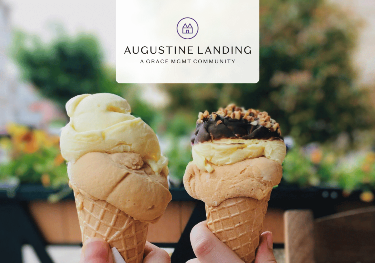 Two ice cream cones held up in front of a blurred outdoor background, with a white rounded card displaying the Augustine Landing logo.